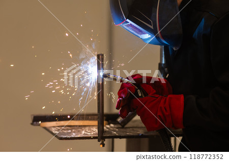 A man learns the craft of welding on a sample.  118772352