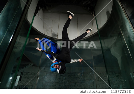 A man and a woman enjoy flying together in a wind tunnel. Free fall simulator A man and a woman enjoy flying together in a wind tunnel. Free fall simulator 118772538