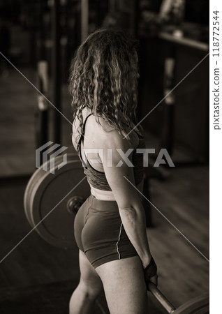 Middle aged woman doing deadlifts in the gym. Middle aged woman doing deadlifts in the gym. 118772544