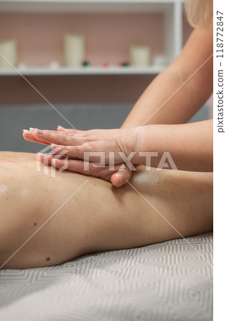 Woman having a therapeutic back massage. Vertical photo.  118772847