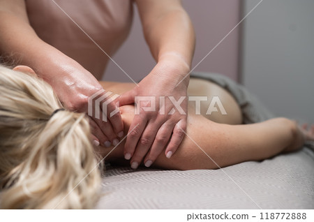 A woman undergoing a massage of the cervical-collar area. A woman undergoing a massage of the cervical-collar area. 118772888