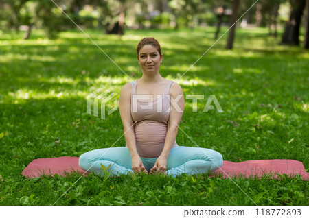 Prenatal yoga. Caucasian pregnant woman doing butterfly pose in the park. Prenatal yoga. Caucasian pregnant woman doing butterfly pose in the park. 118772893
