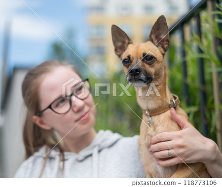 Young Caucasian woman and cute little dog walking.  118773106