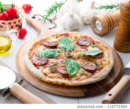 Italian pizza topped with plenty of salami and basil 118773369