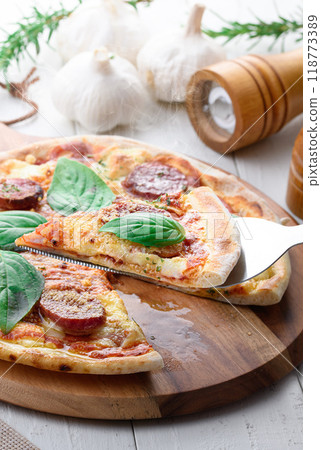 Italian pizza topped with plenty of salami and basil 118773389