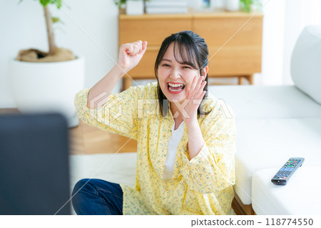 A young lady watching TV in the living room 118774550