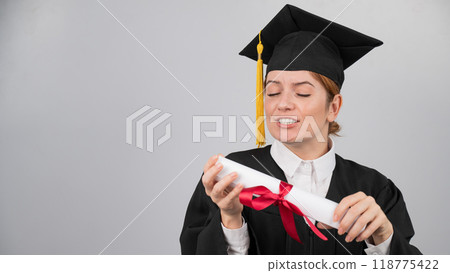 Smiling woman in graduation gown holding diploma on white background. Smiling woman in graduation gown holding diploma on white background. 118775422