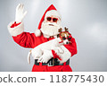 Portrait of santa claus in sunglasses and dog jack russell terrier in rudolf reindeer ears on a white background.  118775430