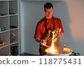 A potter burns a jug with a gas burner on a potter's wheel.  118775431