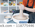 Close-up of a potter's hands working on a pottery wheel.  118775446