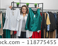 A fat woman chooses clothes by comparing them in a plus size store. 118775455