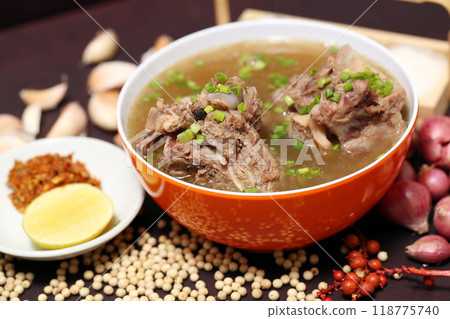 oxtail rib soup or Beef soup in red bowl with ingredients on wooden background, closeup photography for banner menu restaurant, flyer poster designs, catalogue food dish oxtail rib soup or Beef soup in red bowl with ingredients on wooden background, closeup photography for banner menu restaurant, flyer poster designs, catalogue food dish 118775740