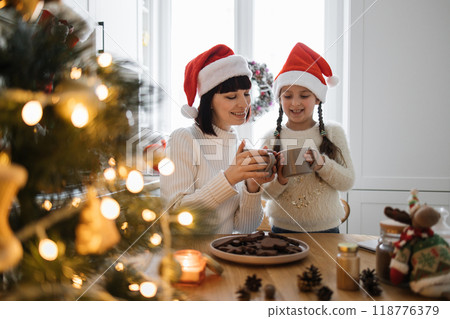 Mother and daughter enjoy hot cocoa on Christmas morning 118776379
