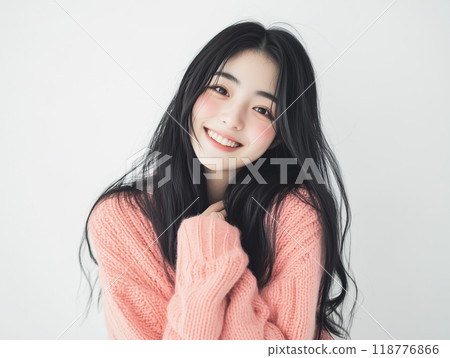 Girl in a pink sweater making a wish 118776866