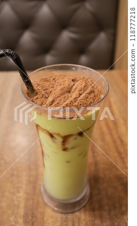 A glass of avocado juice with sprinkle of cocoa powder topping on the table. A glass of avocado juice with sprinkle of cocoa powder topping on the table. 118777218