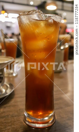 A tall glass of ice tea on the table. A tall glass of ice tea on the table. 118777284