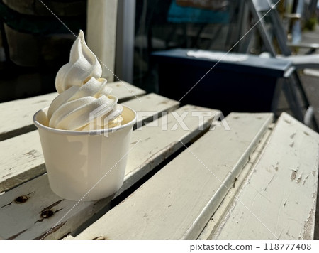 Soft serve ice cream in a cup on a bench 118777408