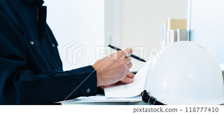 A man in work clothes checking documents 118777410