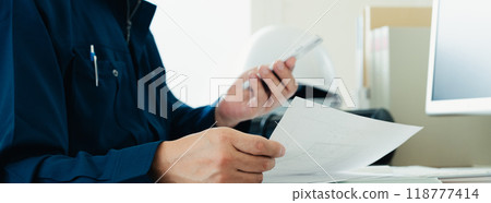 穿著工作服的男人檢查文件 118777414