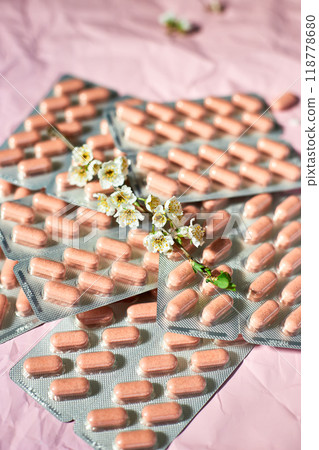 Overhead View of Multiple Blister Packs of Medication on a Crumpled Pink Surface 118778680