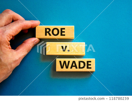 Abortion process Roe versus Wade symbol. Concept words Roe versus Wade on wooden blocks. Lawyer hand. Beautiful blue table blue background. Abortion process Roe versus Wade concept. Copy space. Abortion process Roe versus Wade symbol. Concept words Roe versus Wade on wooden blocks. Lawyer hand. Beautiful blue table blue background. Abortion process Roe versus Wade concept. Copy space. 118780239