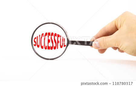 Successful symbol. Concept word Successful in beautiful magnifying glass. Beautiful white paper background. Businessman hand. Business successful concept. Copy space. 118780317