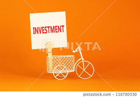 Investment symbol. Concept word Investment on beautiful white paper on clothespin. Beautiful orange background. Beautiful miniature white bicycle. Business investment concept. Copy space. 118780330