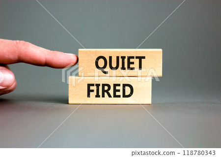 Quiet fired symbol. Concept words Quiet fired on wooden blocks. Beautiful grey table grey background. Businessman hand. Business and quiet fired concept. Copy space. 118780343