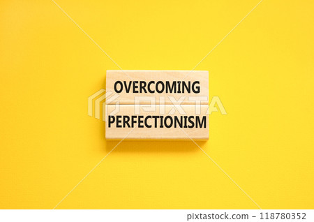 Overcoming perfectionism symbol. Concept words Overcoming perfectionism on beautiful wooden block. Beautiful yellow paper background. Business Overcoming perfectionism concept. Copy space. 118780352
