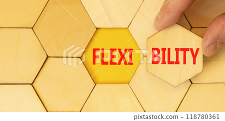 Flexibility symbol. Concept word Flexibility on beautiful wooden puzzles. Beautiful yellow background. Businessman hand. Business flexibility concept. Copy space. Flexibility symbol. Concept word Flexibility on beautiful wooden puzzles. Beautiful yellow background. Businessman hand. Business flexibility concept. Copy space. 118780361