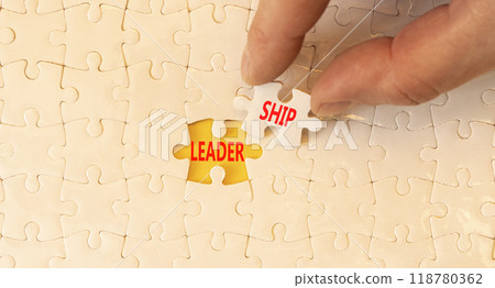 Leadership symbol. Concept word Leadership on beautiful white puzzles. Beautiful yellow background. Businessman hand. Business leadership concept. Copy space. 118780362