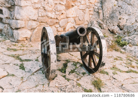 Cannon on a carriage located on a white stone pedestal near the arsenal building in Mirow Castle. Sites of Poland. Architecture of World Tourism. 118780686