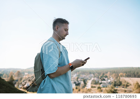 Travel, map and Caucasian man pointing in city for adventure by the phone on the top of mountain, holiday or directions in MIrow Castle, Poland. Tourist, young male with document for location, search Travel, map and Caucasian man pointing in city for adventure by the phone on the top of mountain, holiday or directions in MIrow Castle, Poland. Tourist, young male with document for location, search 118780693