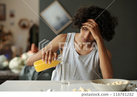 Teenage guy having breakfast after booze Teenage guy having breakfast after booze 118781282