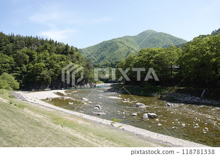 Beautiful green mountains and clear streams. A suspension bridge can be seen in the distance. 118781338
