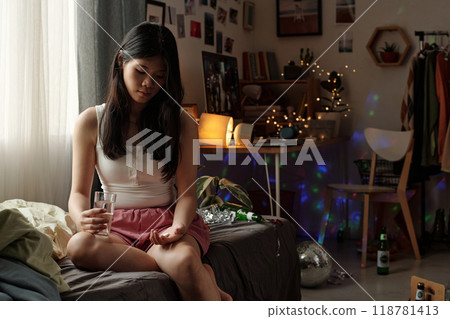 Sad girl with glass of water and pill Sad girl with glass of water and pill 118781413