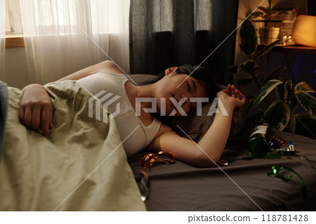 Young woman with hangover lying on bed 118781428
