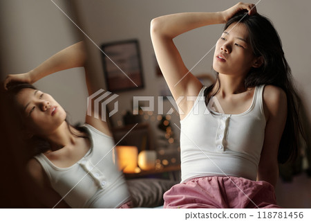 Woman with hangover touching her hair Woman with hangover touching her hair 118781456
