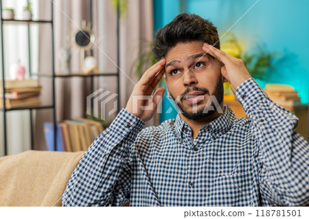 Sick ill Indian man rubbing temples to cure headache problem, suffering from migraine, stress Sick ill Indian man rubbing temples to cure headache problem, suffering from migraine, stress 118781501