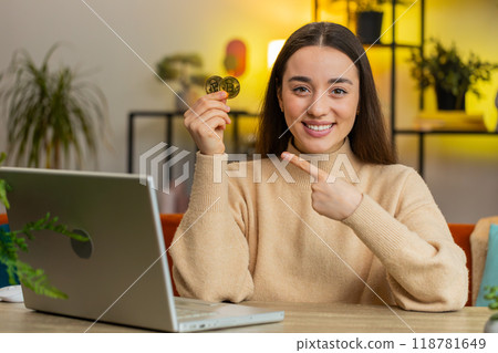 Woman stock trader earning bitcoins after online monitoring trading operations mining hold BTC coins 118781649