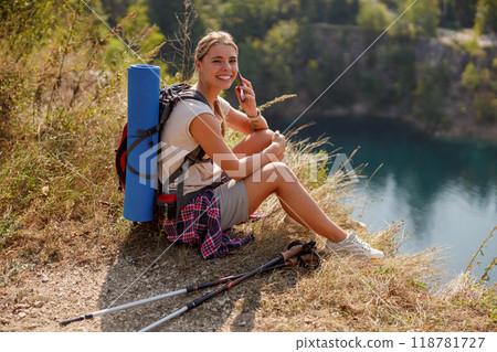 A Happy Smiling Hiker Enjoying a Relaxing Break by the Beautiful Water on a Scenic Day A Happy Smiling Hiker Enjoying a Relaxing Break by the Beautiful Water on a Scenic Day 118781727