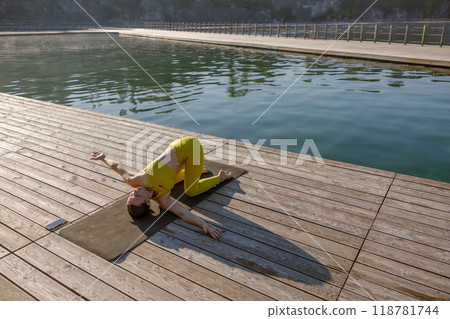 Engage in a Yoga Practice by the Water Experience a Serene Outdoor Setting Today 118781744