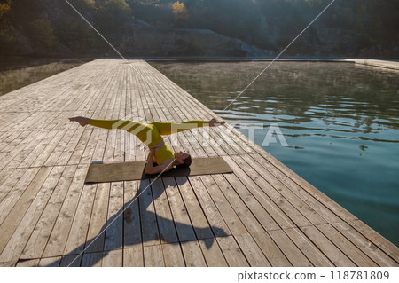 Engaging in a Serene Yoga Practice by the Water while Watching the Sunrise is Refreshing 118781809