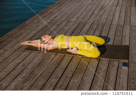 Engaging in a Yoga Pose on the Dock Enjoy a Serene and Invigorating Stretch by the Water Engaging in a Yoga Pose on the Dock Enjoy a Serene and Invigorating Stretch by the Water 118781811