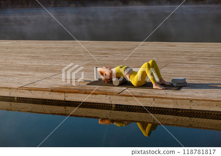 Engaging in a Serene Yoga Practice by the Water at Sunrise is truly refreshing and invigorating 118781817