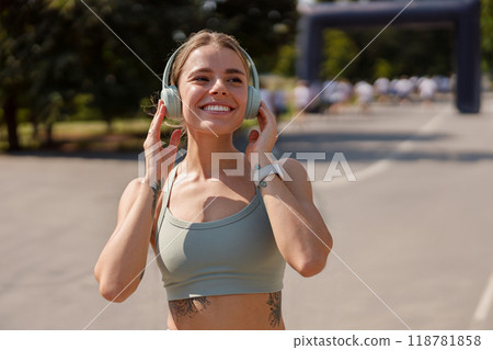 A Young Woman Happily Enjoying Her Favorite Music While Jogging Outdoors in Nature A Young Woman Happily Enjoying Her Favorite Music While Jogging Outdoors in Nature 118781858