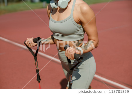 Athletic Woman Engaging in Intensive Training with Resistance Bands on a Track Surface 118781859