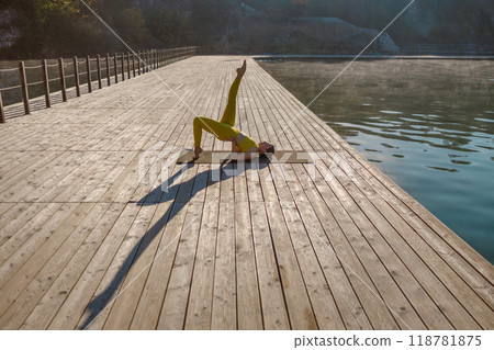 Experience a Serene Yoga Practice on a Peaceful Dock by the Water Surrounded by Nature Experience a Serene Yoga Practice on a Peaceful Dock by the Water Surrounded by Nature 118781875