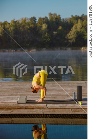 Engaging in a refreshing Morning Yoga Practice amidst the tranquility of the Lake Engaging in a refreshing Morning Yoga Practice amidst the tranquility of the Lake 118781906