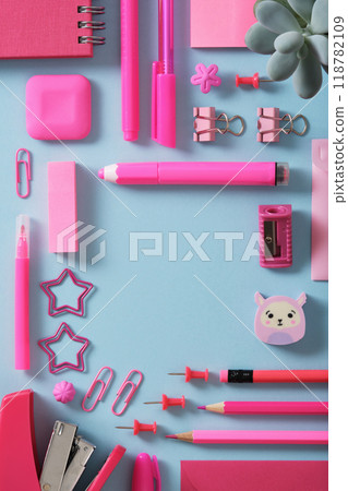 Pink stationery frame of felt pens, pencils, eraser, paper clips, pins, sharpener, stapler. Light blue background, space for your text. Pink stationery frame of felt pens, pencils, eraser, paper clips, pins, sharpener, stapler. Light blue background, space for your text. 118782109
